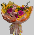 Colorful spring flower bouquet with yellow roses, pink gerberas, and fresh seasonal blooms.