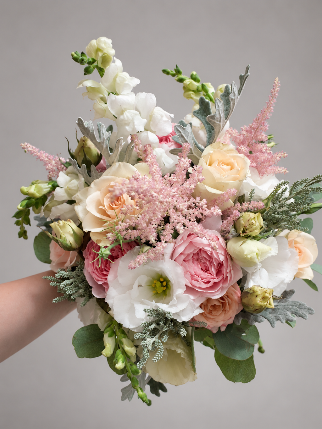 Blush and ivory bridal bouquet with roses, pink astilbe and silver foliage, view 1