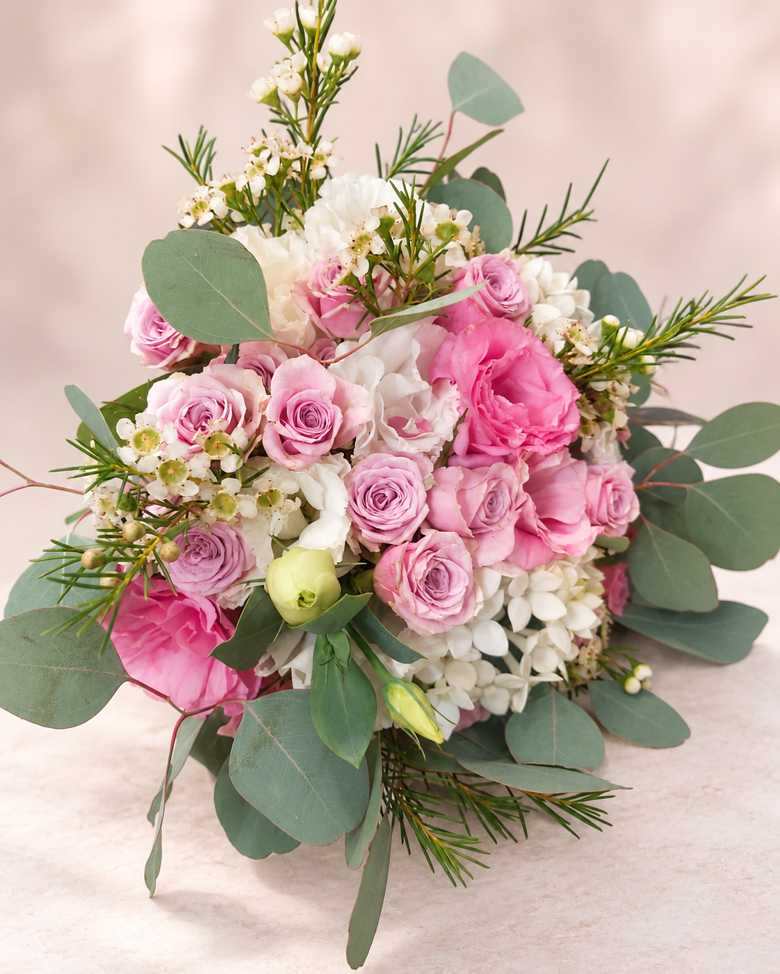 Close-up of blush pink rose wedding bouquet with eucalyptus and white flowers