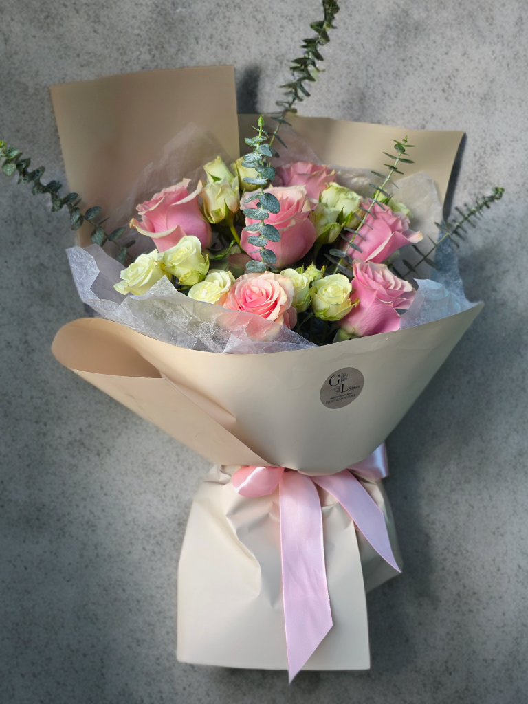Elegant blush pink rose bouquet with white spray roses, eucalyptus, luxury wrapping, and pink satin ribbon