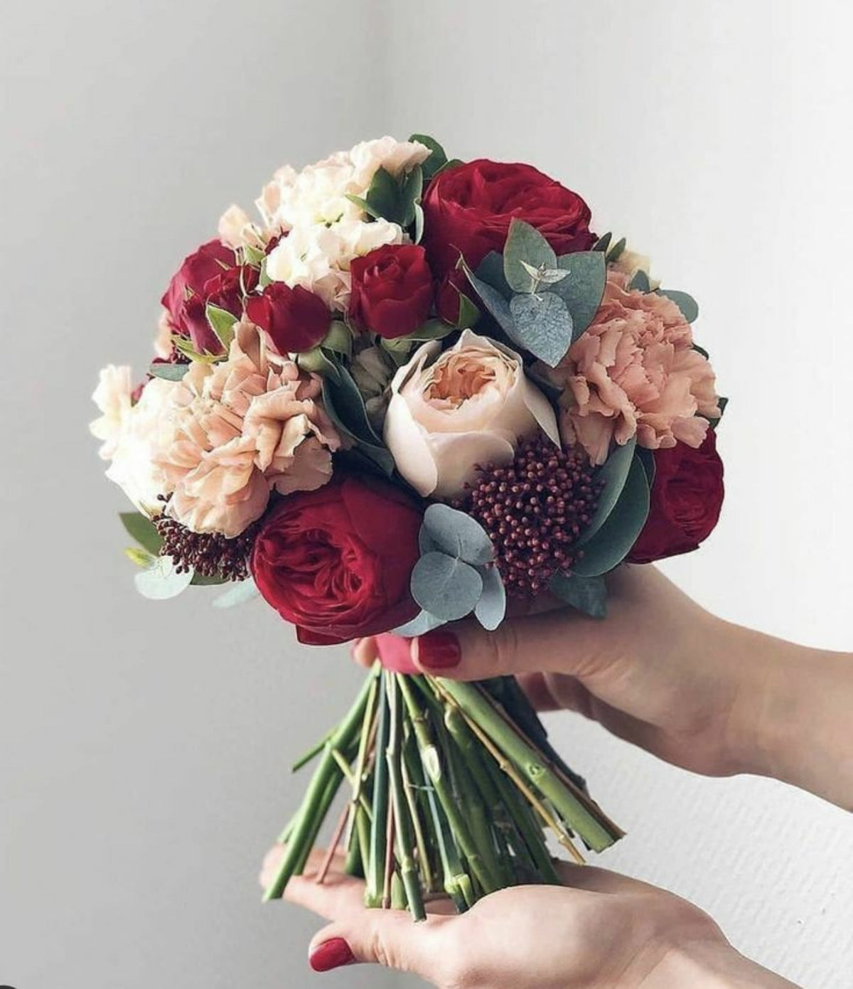 Burgundy and blush bridal bouquet with roses, peach carnations and eucalyptus