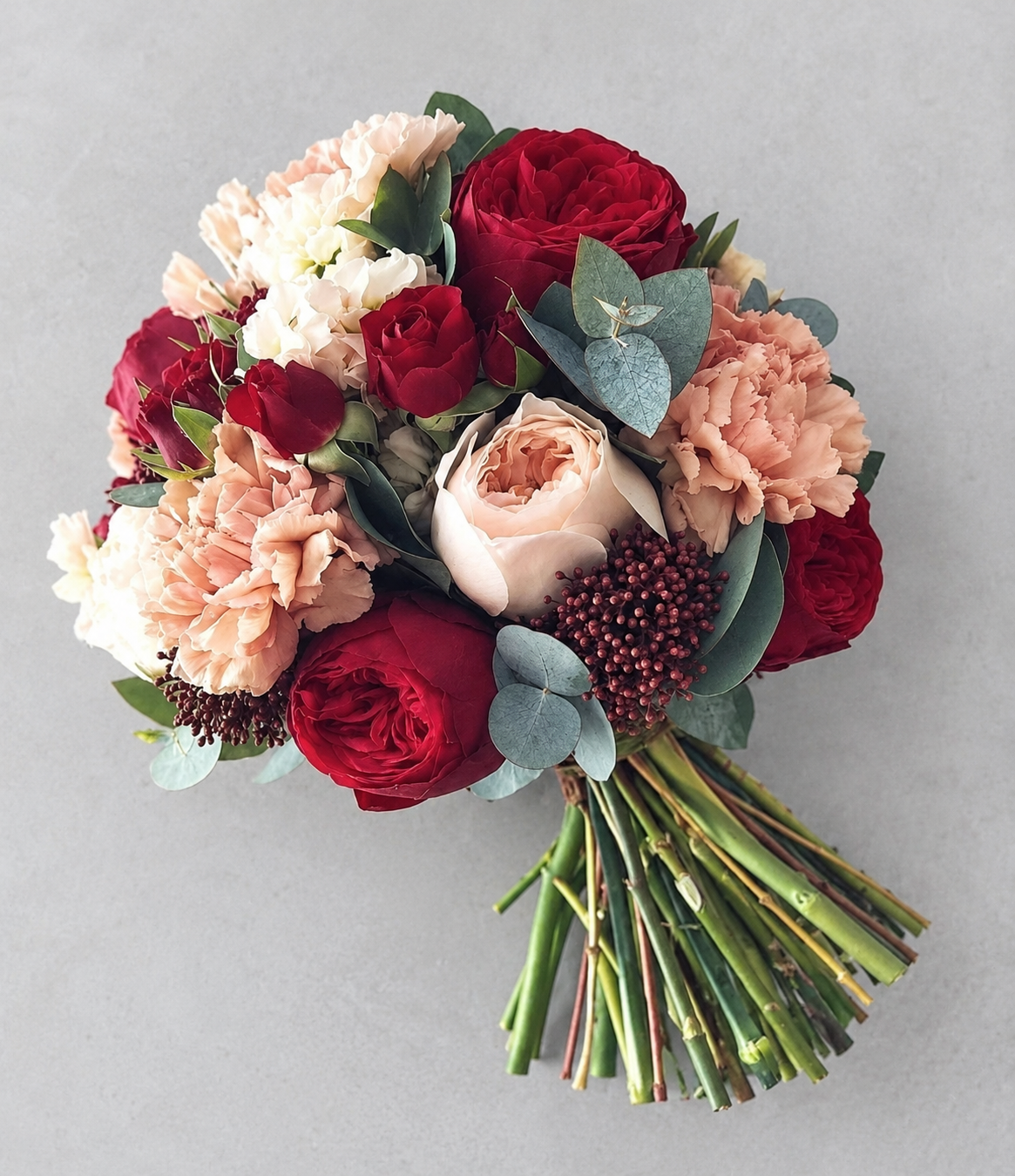 Overhead view of burgundy roses and peach carnations bridal bouquet