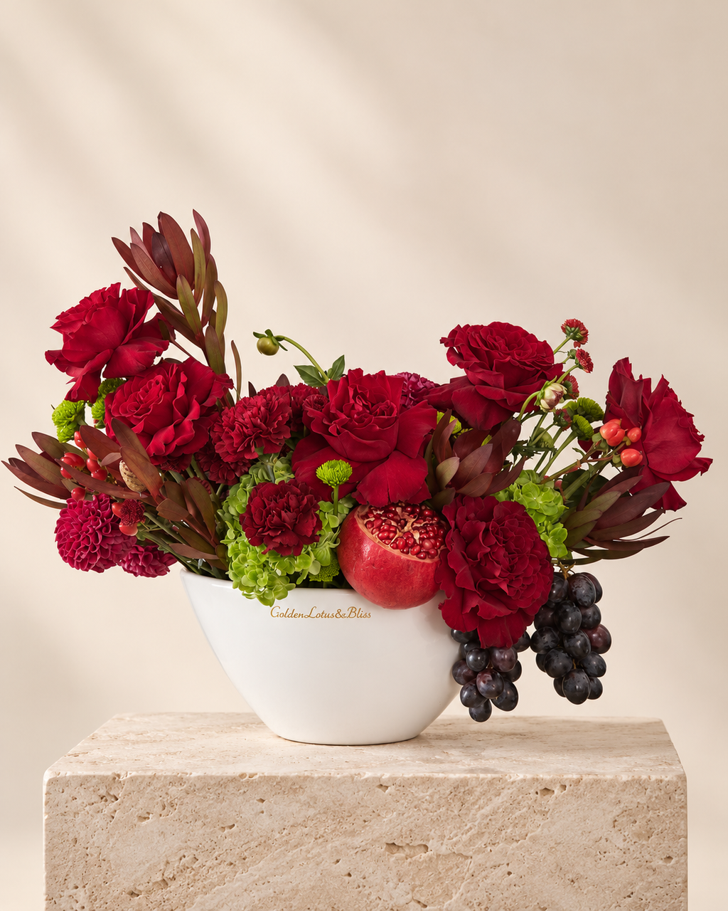 Burgundy luxury floral arrangement with pomegranate and grapes in a white ceramic boat vase