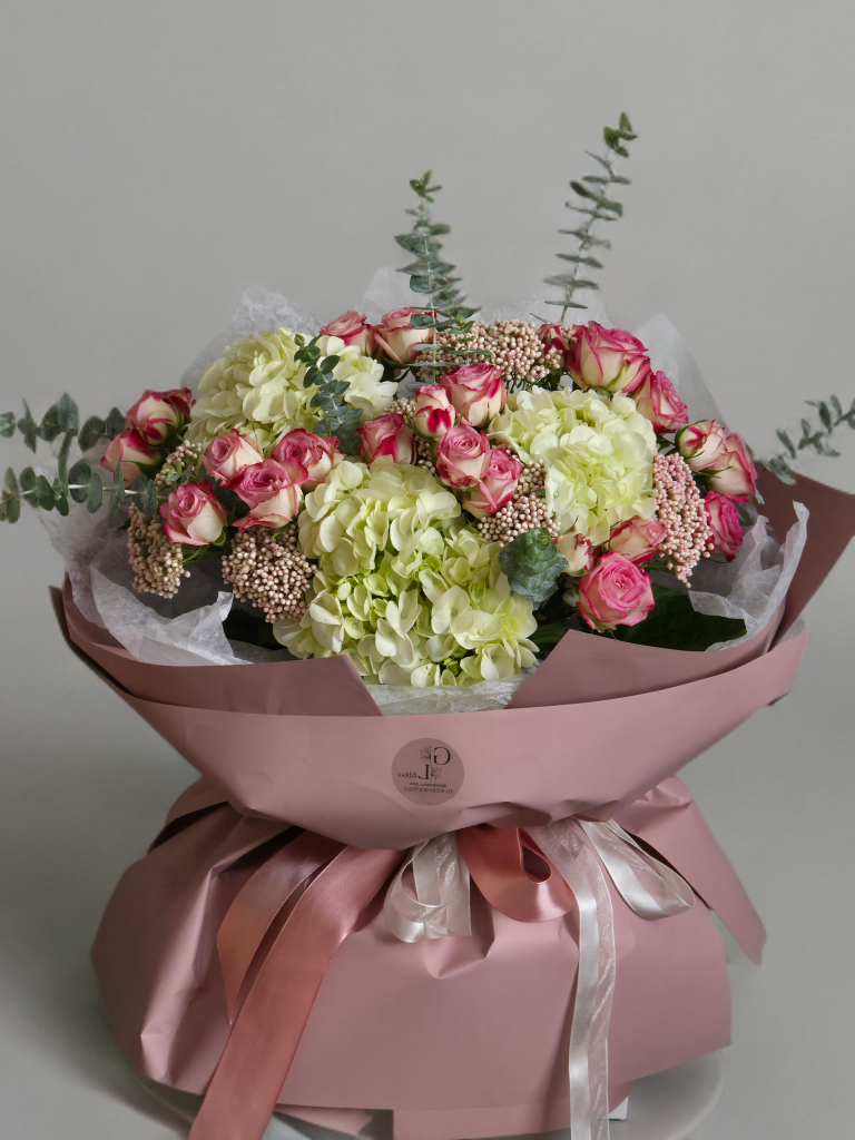White hydrangea and pink spray rose bouquet with eucalyptus in blush wrapping