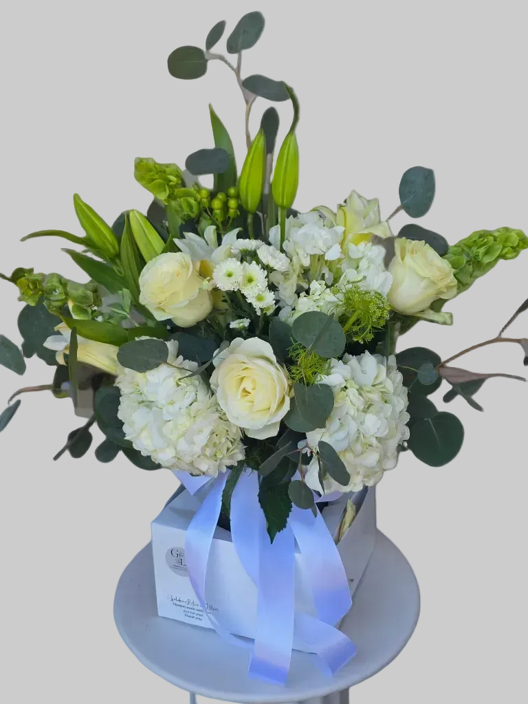Luxury white bouquet with roses, hydrangeas, lilies, and eucalyptus in elegant floral box