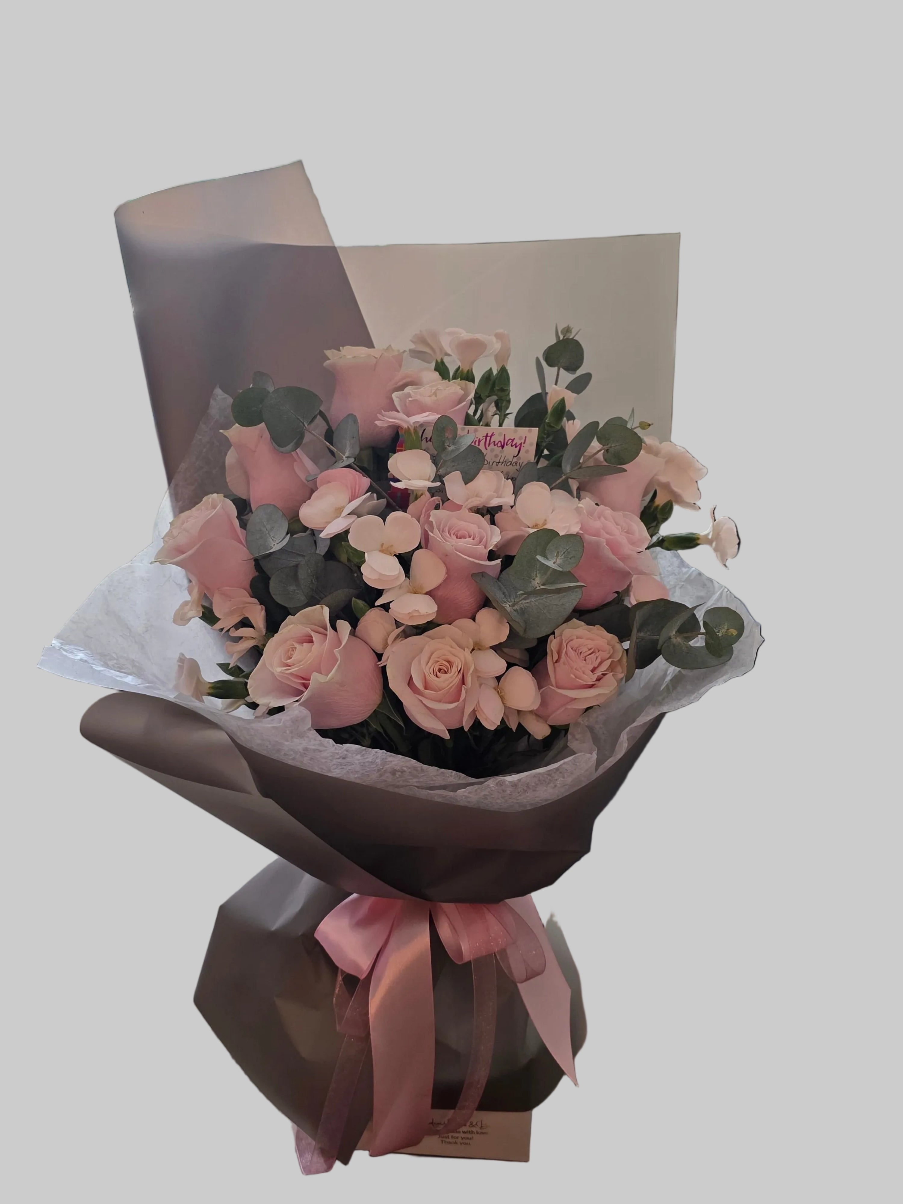 Luxury blush pink rose bouquet with eucalyptus, soft seasonal flowers, elegant wrapping, and satin ribbon