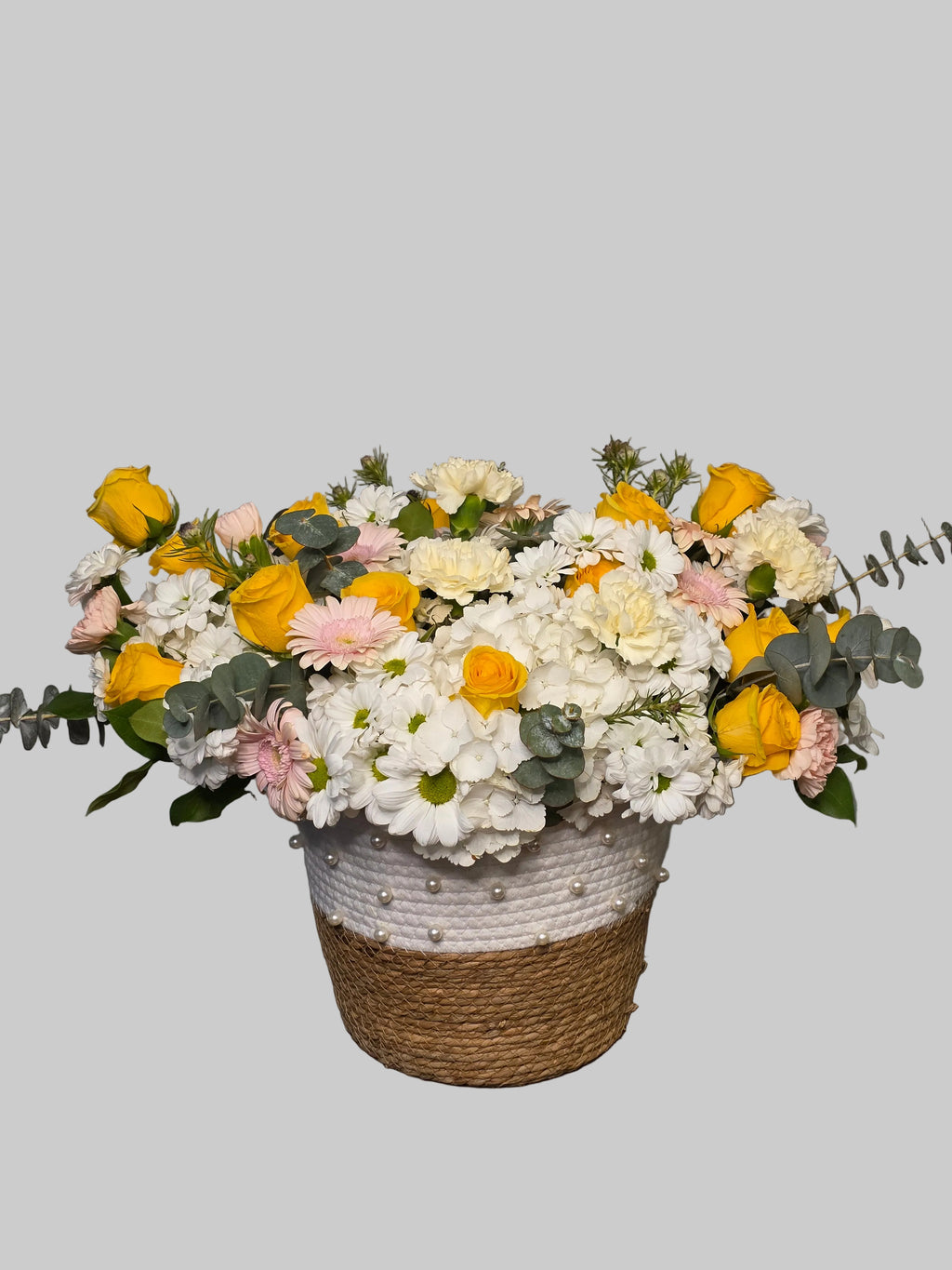 Yellow and white flower basket arrangement with roses, hydrangea, daisies, and eucalyptus